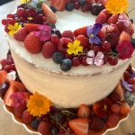 Marscarponetaart met aardbeien en frambozenvulling, vers fruit en eetbare bloemen